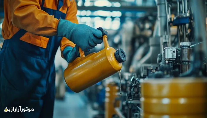 تکنسین صنعتی در حال روغنکاری دقیق تجهیزات با استفاده از ظرف فلزی مخصوص روانکار؛ نمونهای از اجرای صحیح عملیات نگهداری پیشگیرانه در کارخانه