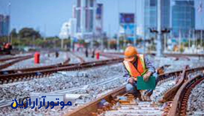 تصویر یک مهندس در حال بررسی ریل قطار