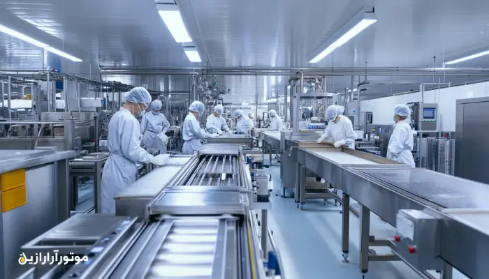 کارخانه مدرن تولید مواد غذایی با کارگران مجهز به لباس بهداشتی و خطوط تمام استیل، در حال کار در یک محیط استریل و ایمن، نشاندهنده الزامات بهداشتی استفاده از روانکارهای غذایی