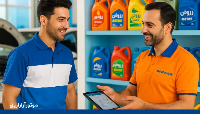 مشاوره فنی روانکار در مشهد؛ گفتوگوی تخصصی تکنسین و کارشناس موتورازین در اتوسرویس، با قفسهای از روغنهای رنگی فارسی و تبلت دیجیتال در دست مشاور