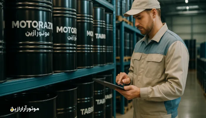 تصویر داخلی انبار مدرن روانکار صنعتی موتورازین در تبریز با کارشناسی که دادههای روغن را روی تبلت بررسی میکند
