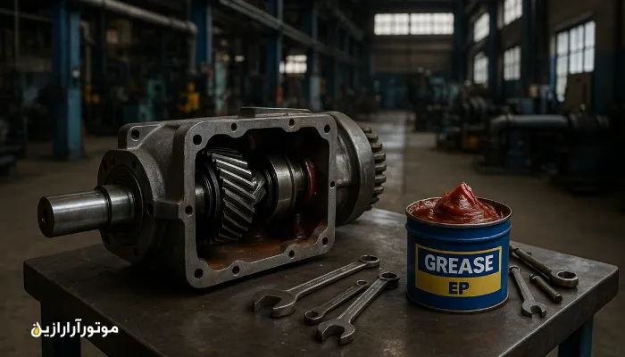 چند گیربکس صنعتی بزرگ در محوطه معدنی همراه با بشکه‌های آبی روغن صنعتی در کنار نوار نقاله سنگ‌شکن – موتورآرا رازین