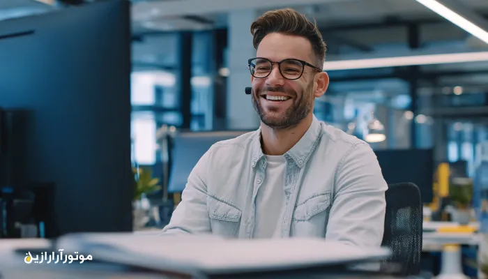 کارشناس خدمات پس از فروش موتورازین (CRM) در حال پشتیبانی مشتریان با لبخند و ارتباط مؤثر در محیط کاری مدرن