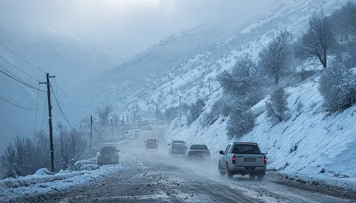 جاده برفی و خودروهای در حال حرکت در مسیر کوهستانی همدان در زمستان، نیازمند روغن صنعتی همدان با عملکرد پایدار در دمای پایین