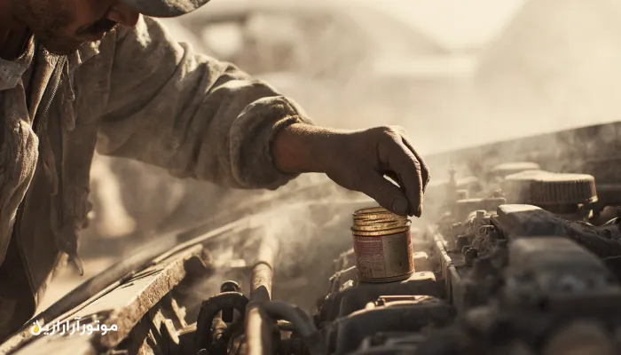 مکانیک در کارگاه نیمه‌کویری قهستان در حال سرویس روغن موتور 5W-30 با برند موتورازین. روغن موتور درمیان